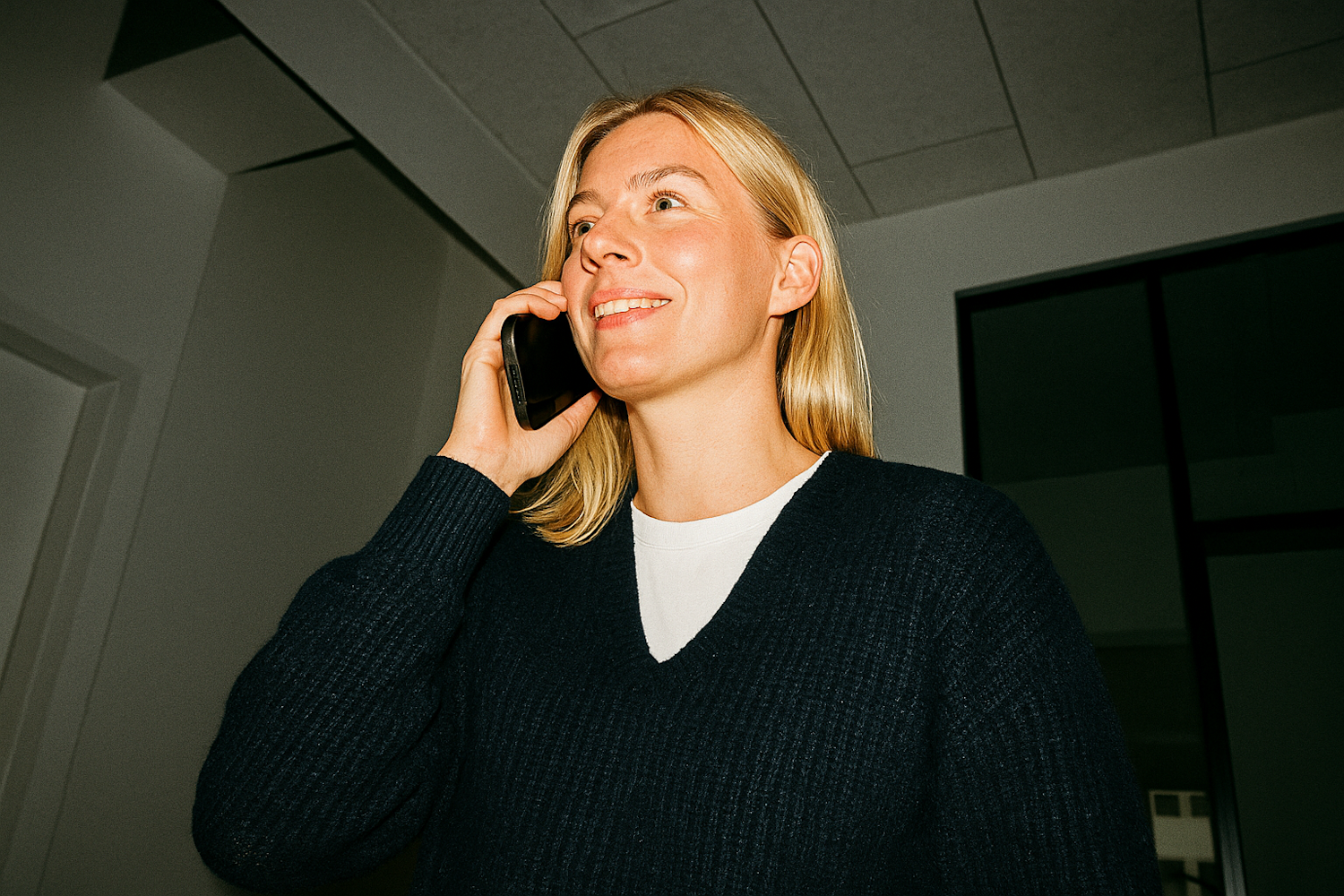 A person engaging with a website on a mobile phone, emphasizing the importance of mobile-first design.