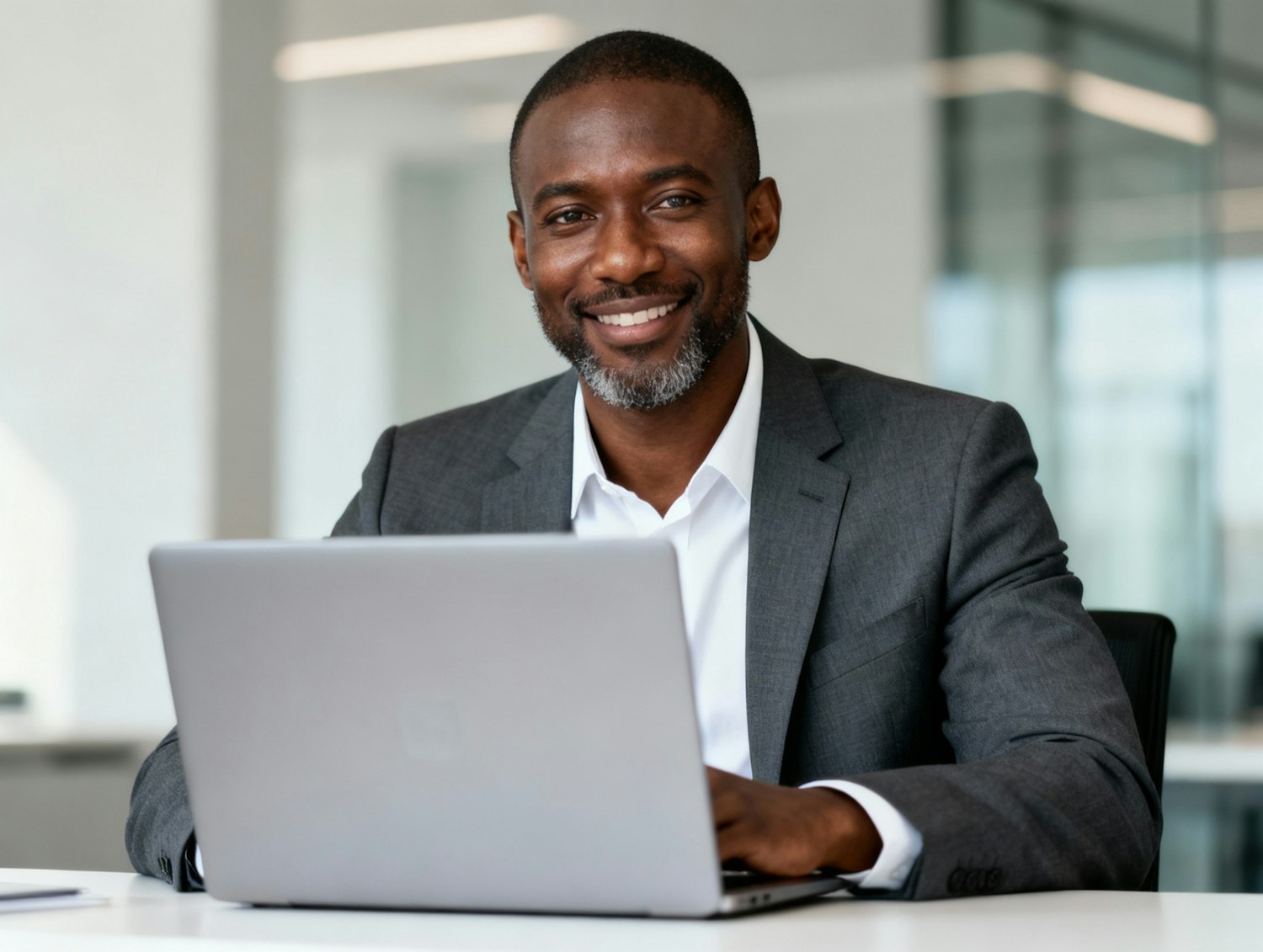 A person confidently working on a laptop in a modern office, representing a business owner thriving with reliable and scalable web hosting.