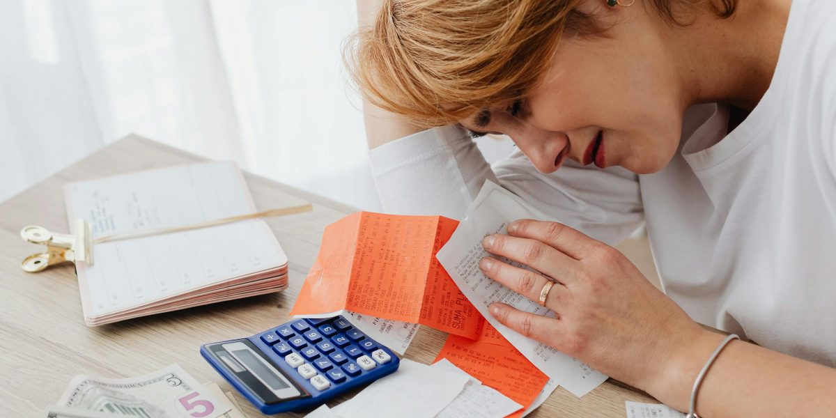 An entrepreneur looks concerned while reviewing documents, reflecting the anxieties about hidden hosting costs and unreliable service.