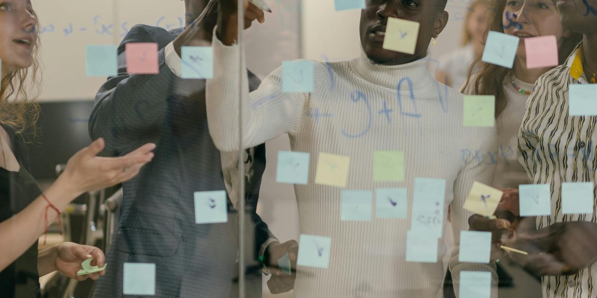A small team collaborating around a whiteboard, representing efficient and responsive support when technical issues arise.