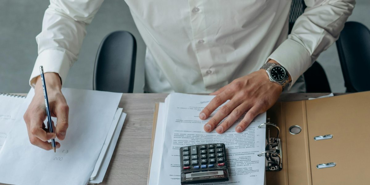 Someone meticulously examining financial documents, emphasizing careful budget planning.