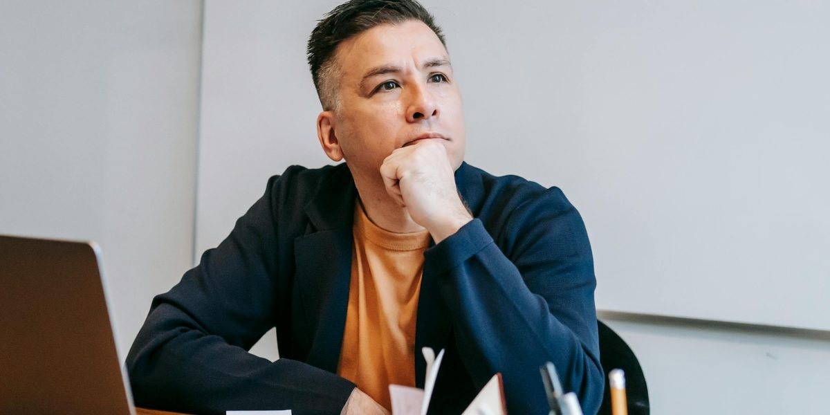 A business professional contemplating the financial implications of self-hosting, balancing initial savings with potential hidden costs.