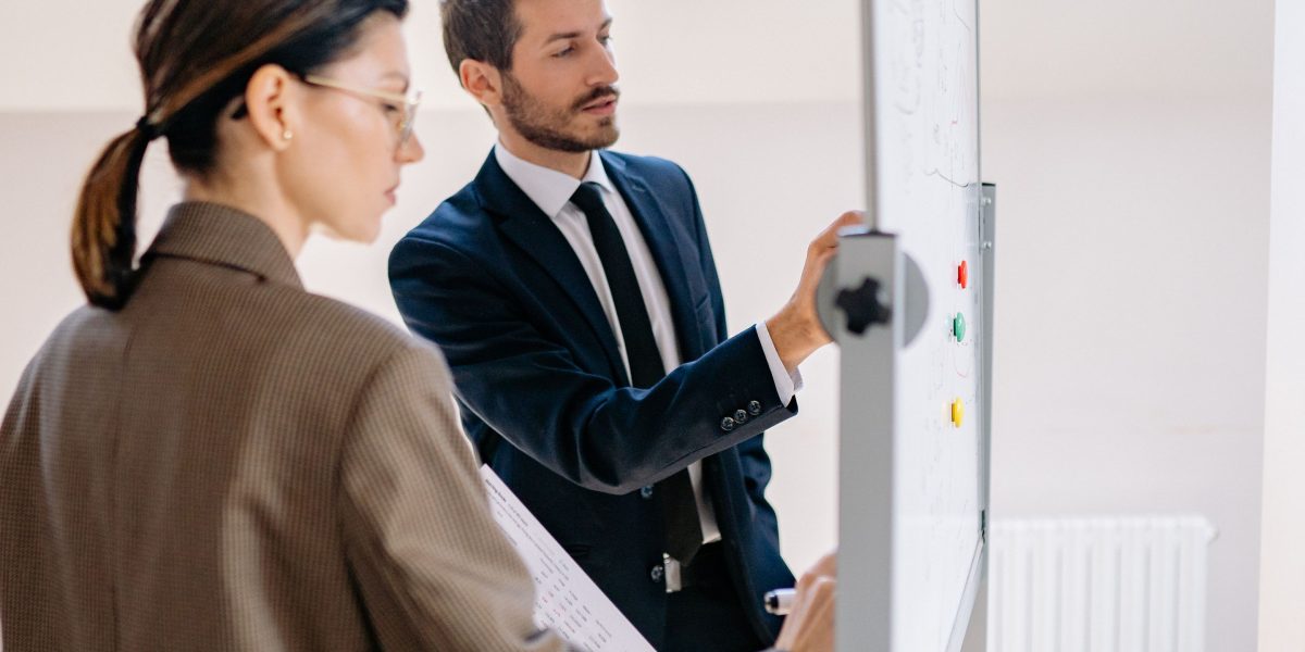 A team collaborates, using a whiteboard to strategize and design intuitive website navigation for better user experience.