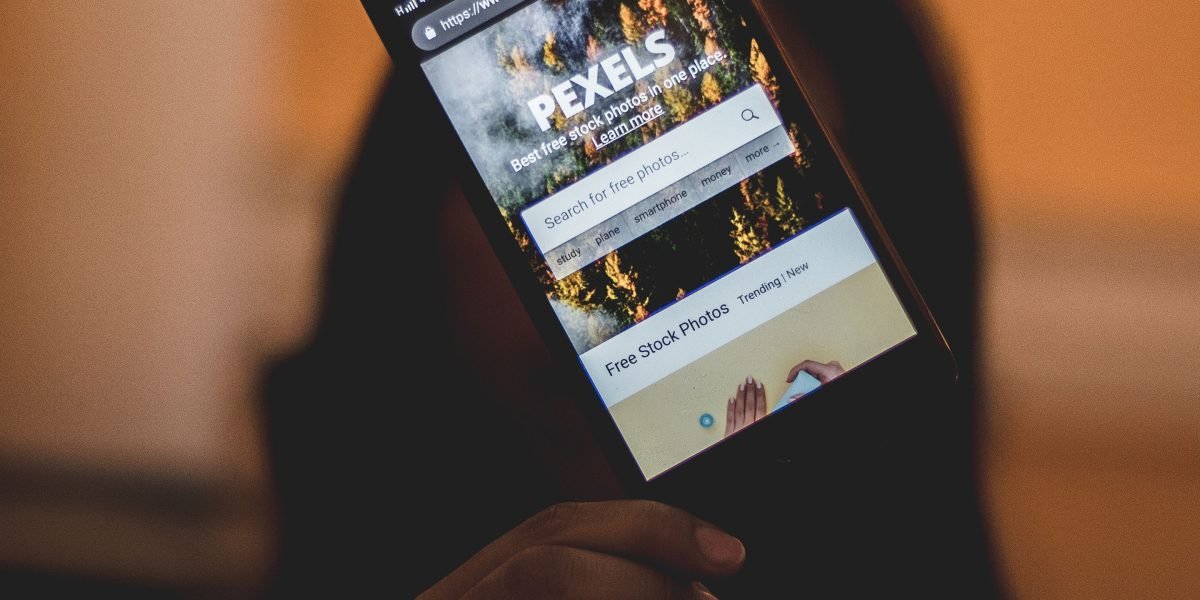 A person viewing a website on a smartphone, demonstrating the importance of mobile responsiveness for modern web design.