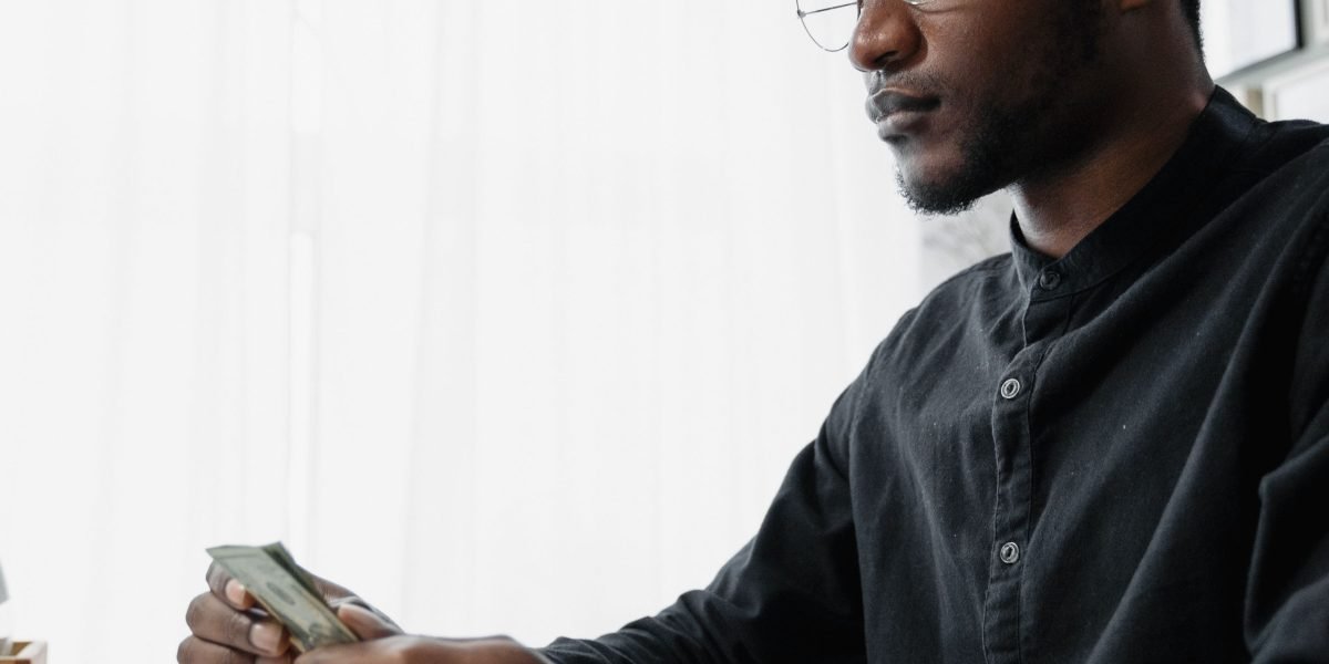 An entrepreneur contemplating business finances, reflecting the need for cost-effective website solutions.