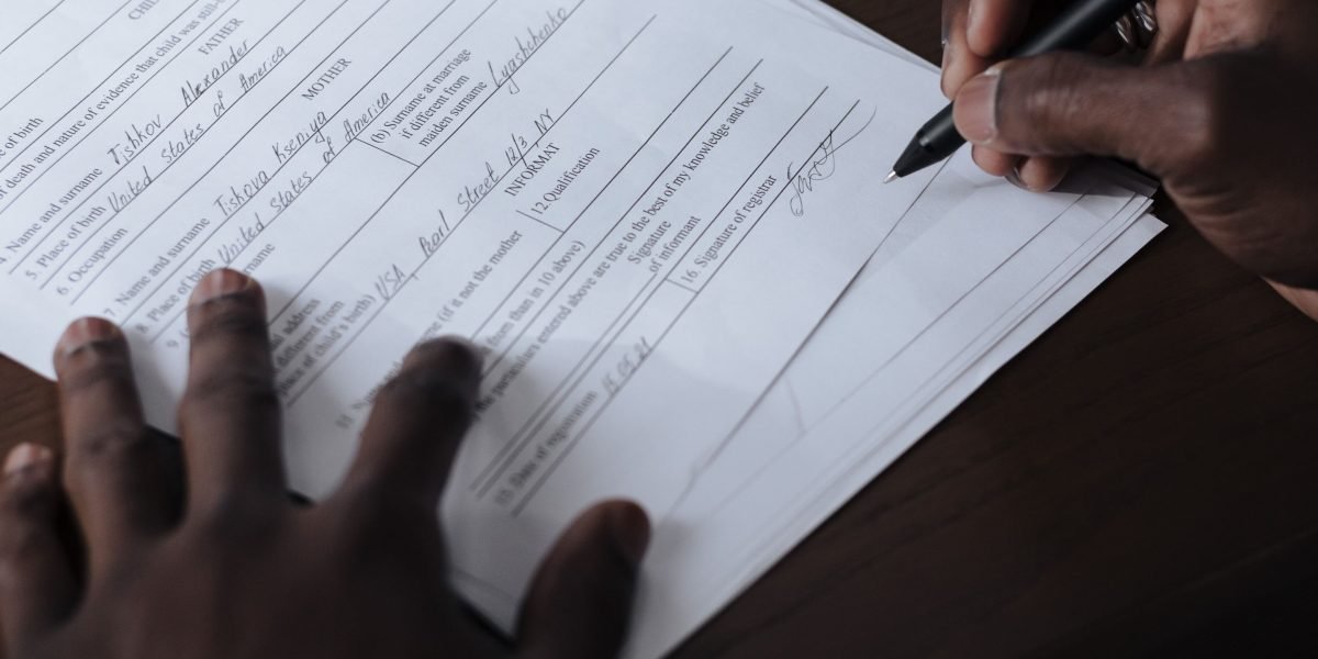 A person intently reviewing detailed documents, symbolizing the need to examine website builder terms and conditions.
