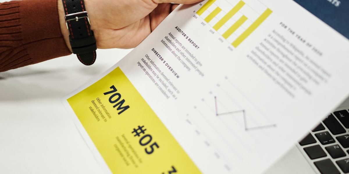 A business professional meticulously reviewing various reports to make informed decisions.