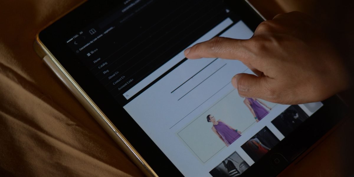A person examining a website on different mobile devices to ensure optimal display and user experience.