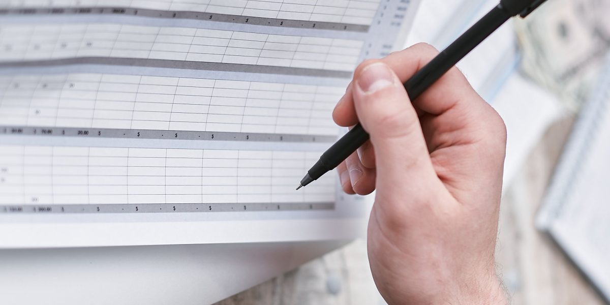 A small business owner meticulously reviews their budget, a common challenge when faced with unpredictable web hosting costs.