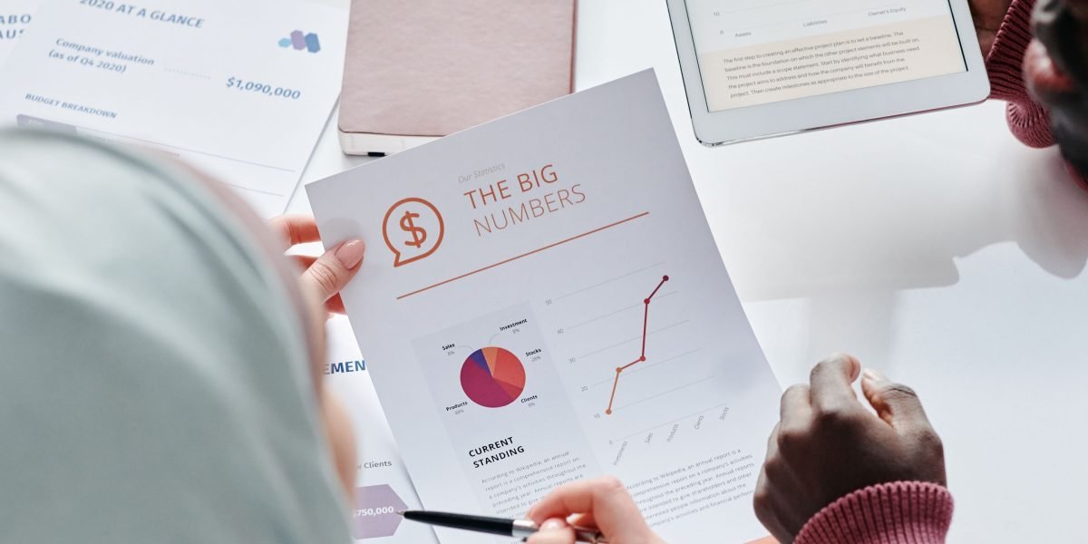 A small business owner carefully reviewing financial documents, symbolizing the challenge of managing web hosting costs.