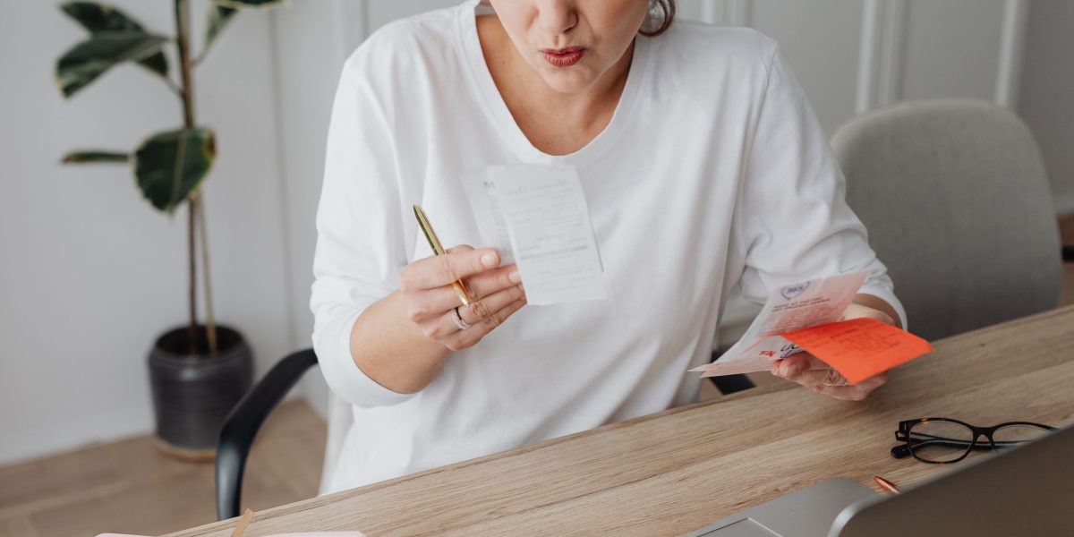 A small business owner reviewing financial documents, emphasizing the importance of budget management for domain costs.