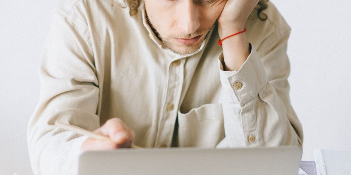 A business owner reviews documents, looking frustrated, symbolizing the challenges of managing a website without a reliable hosting partner.