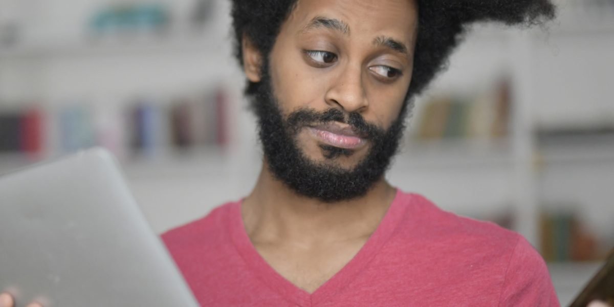 An individual thoughtfully considers different options, symbolizing the balance between SEO and brandability.