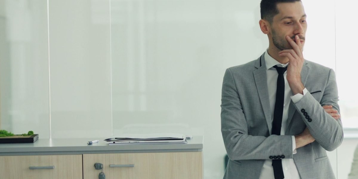 An entrepreneur thoughtfully considering important business decisions for their online presence.